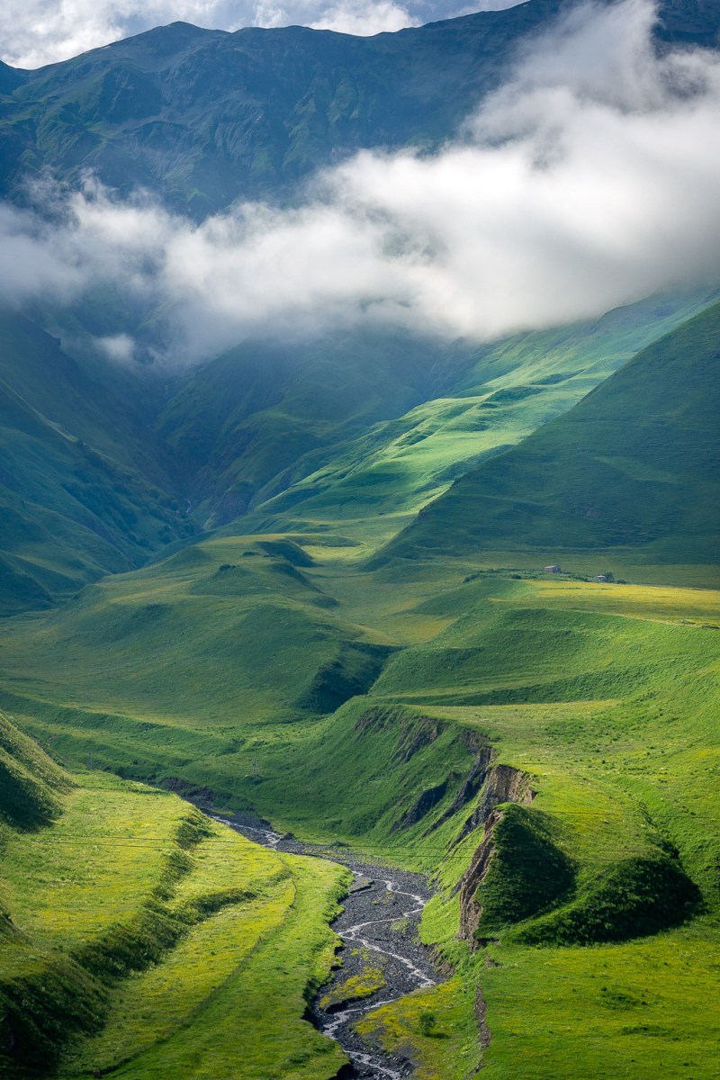 A river runs through a deep valley, Kazbegi, Georgia.