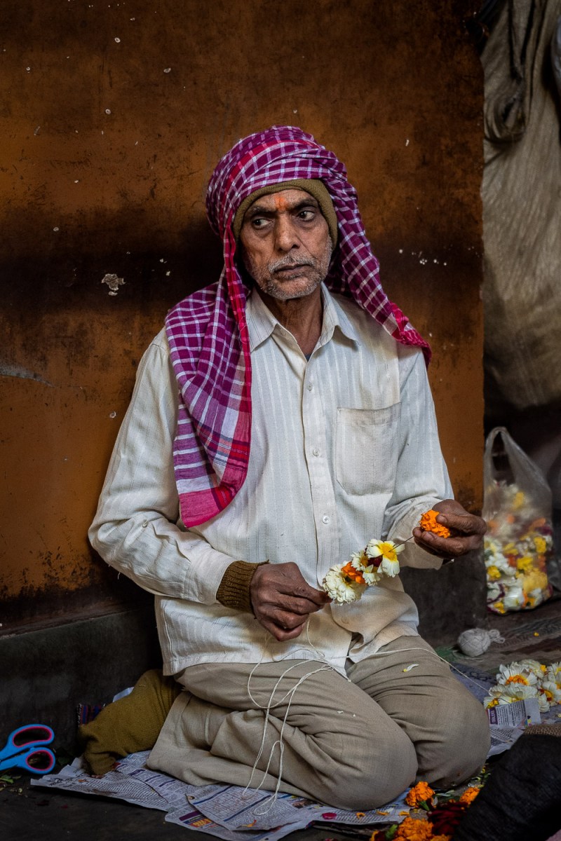 Man making flower decorations, Old Delhi, India.