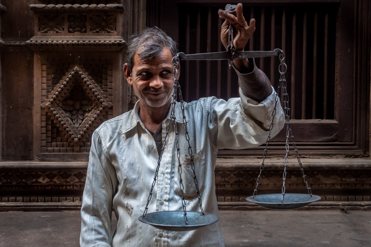 Man with a food scale, Old Delhi, India.
