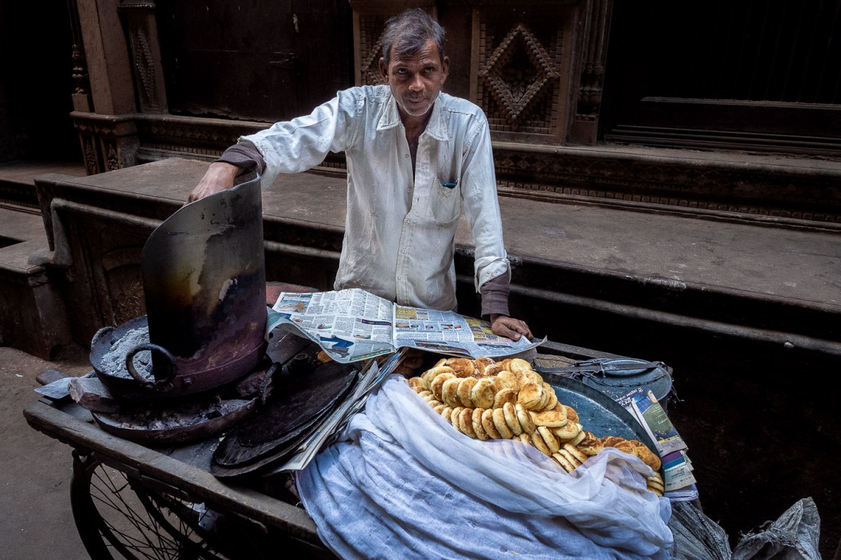 Salesman reading the newspaper, Old Delhi, India.