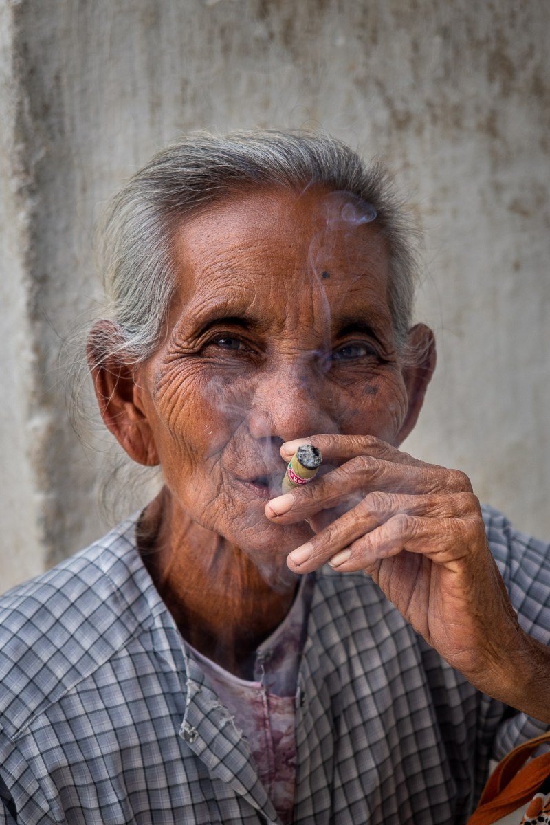 Woman smoking a cigar, Mandalay, Myanmar.