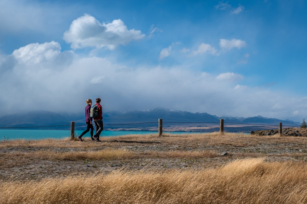 Couple walking along Lake Pukaki, Canterbury, New Zealand.