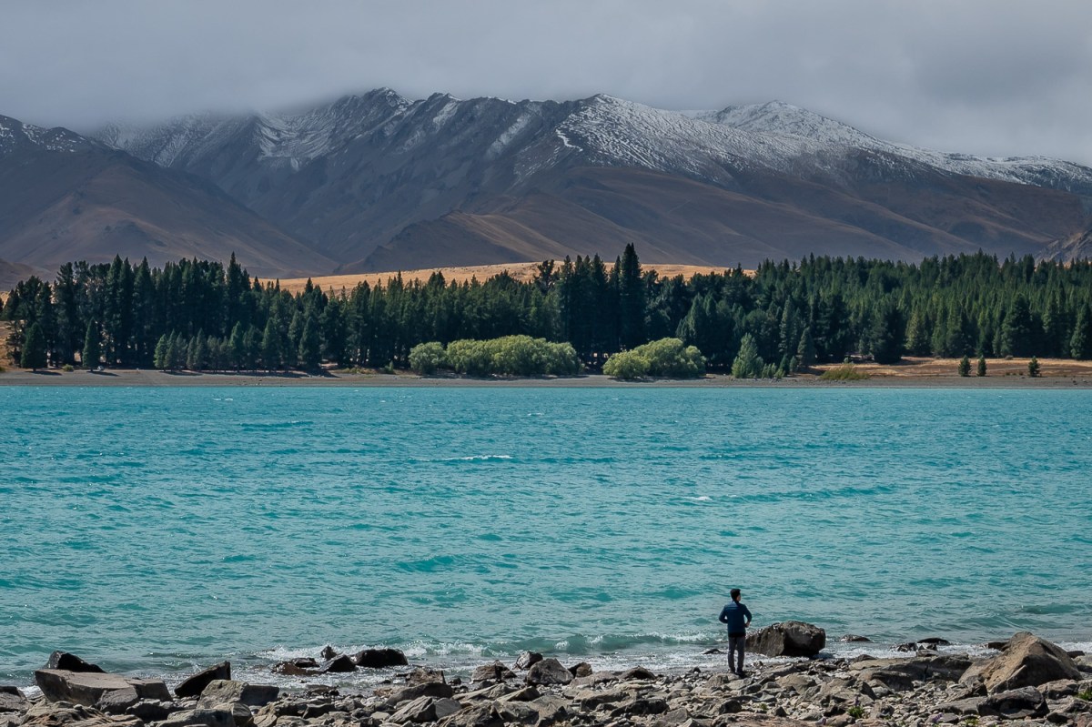 Man standing on the shore of Lake Tekapo, Canterbury, New Zealand.