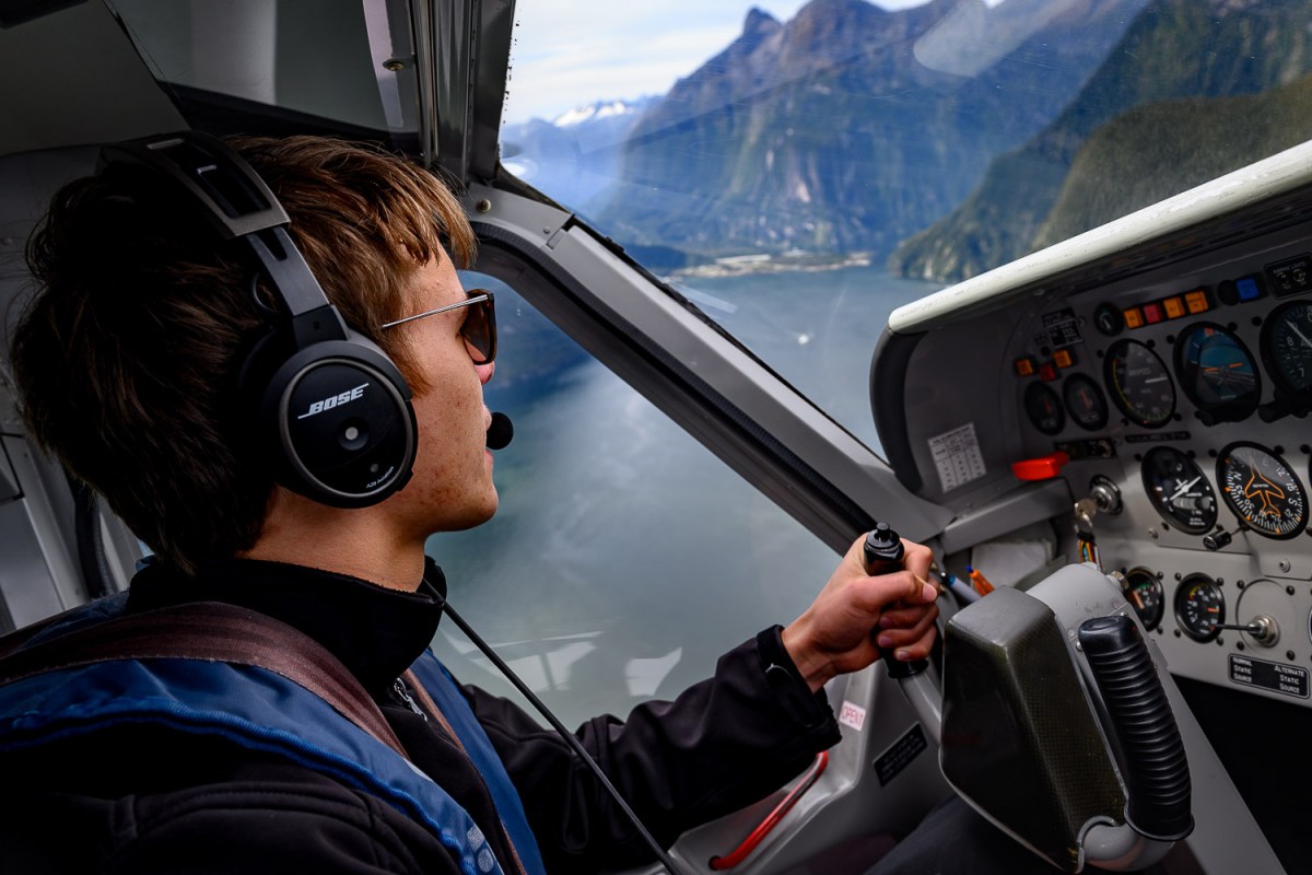 A young pilot navigating through the mountains, Milford Sound, New Zealand.